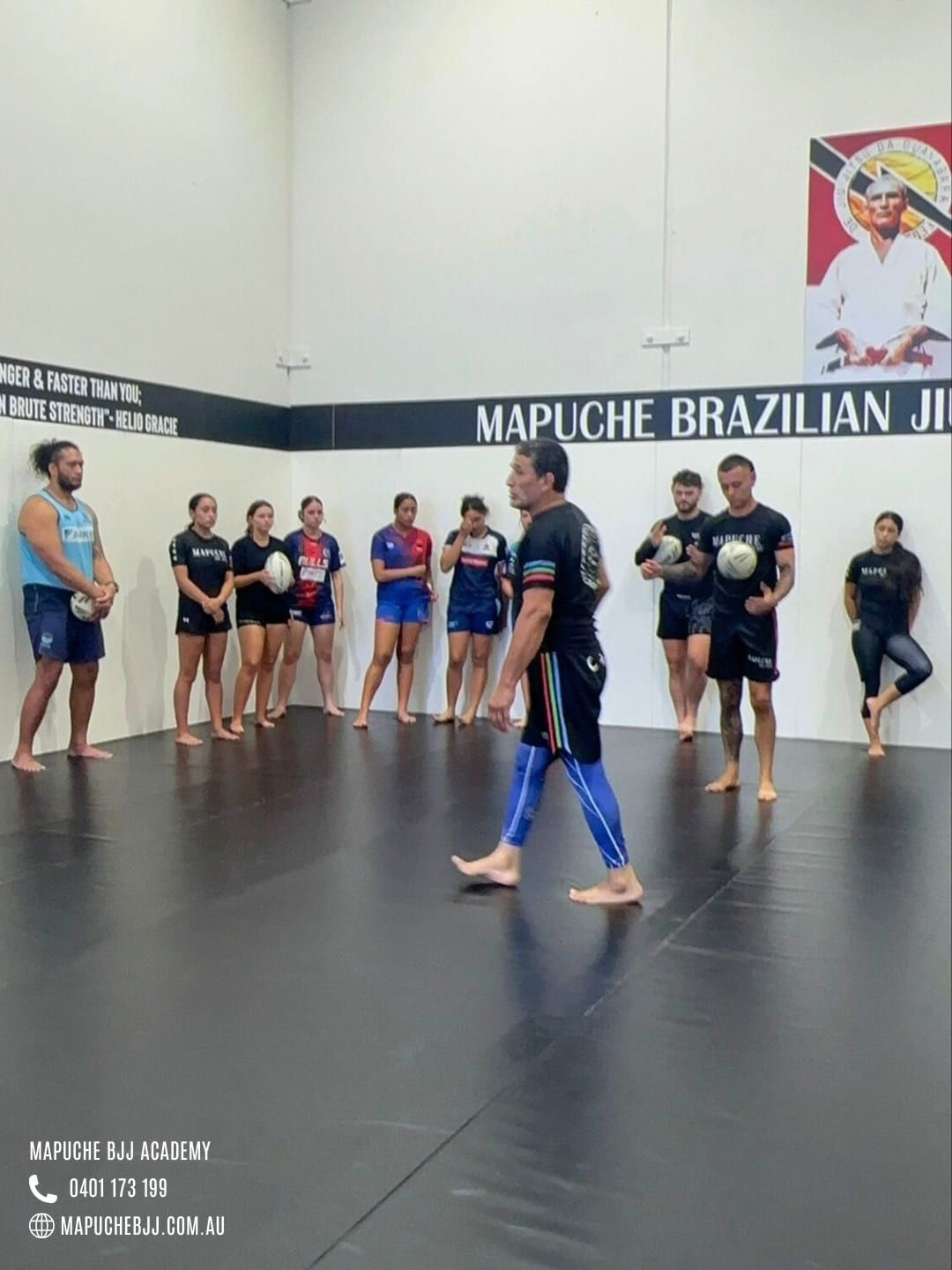 Adults lined up on the mat at the start of a beginners class