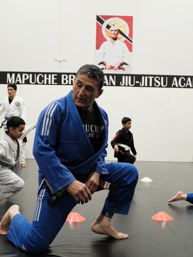 The head instructor coaching on the mat during an all levels session