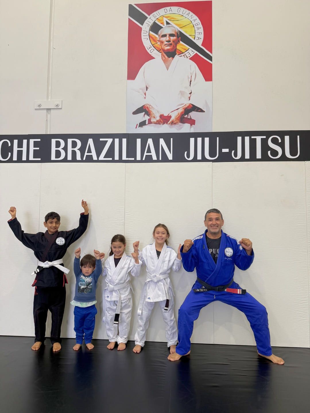 Young children celebrating with their coach after a kids class